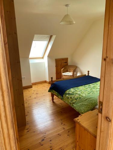 a bedroom with a bed and a window at The Cliffs of Moher House, Doolin in Doolin