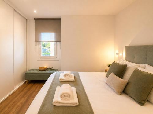 a bedroom with a large bed with towels on it at Holibai Portaliña, Mar y Montaña, Baiona in Baiona