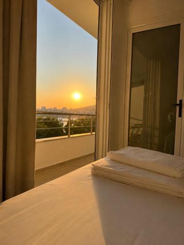 a bedroom with a bed with a view of the sunset at Hotel Barjami in Sarandë