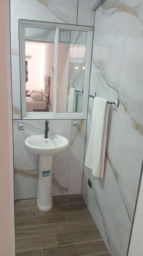 a bathroom with a sink and a mirror at Macao Sky pool suites in Punta Cana