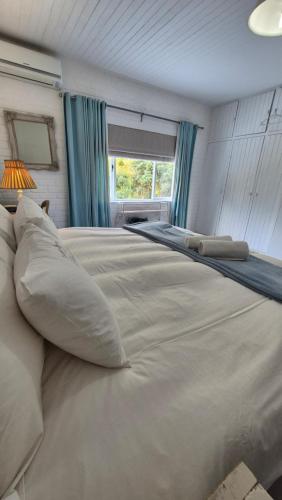 a large white bed with pillows and a window at The Ark Holiday Home in Stanford