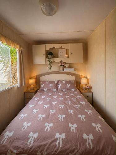 a bedroom with a bed with a pink comforter at 7 Jay Valley in Bridlington