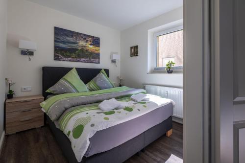 ein Schlafzimmer mit einem Bett und einem Fenster in der Unterkunft Harzer-Geißen Lounge in Hohegeiß