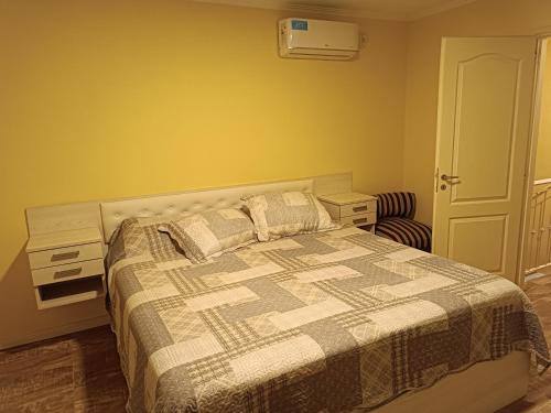 a bedroom with a bed and a chair at Melo 2203 Duplex 1 in Belén de Escobar