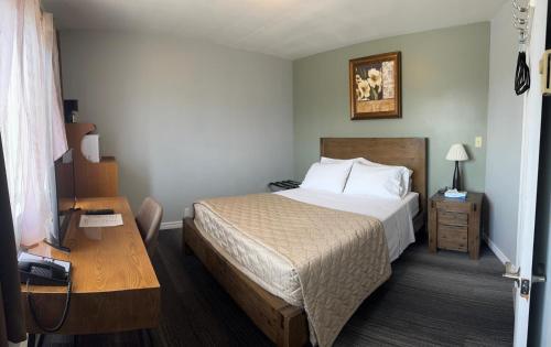 a hotel room with a bed and a desk at Hawberry Motel in Little Current