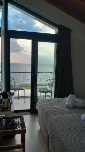 a bedroom with a bed and a view of the ocean at Saos Terra Suites in Samothraki