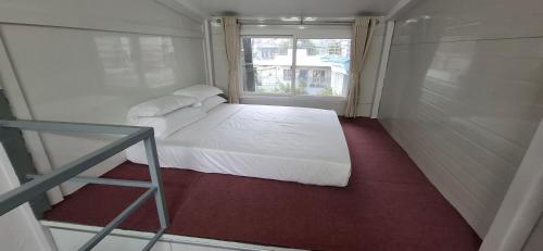 a small bedroom with a white bed and a window at Square Accommodation Rudra kunj in Pokhara