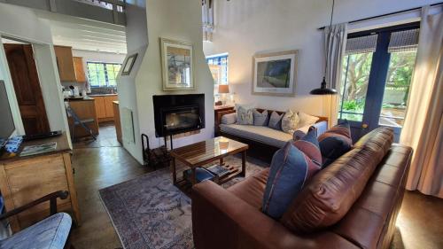 a living room with a leather couch and a fireplace at Lavender’s Blue in Stanford