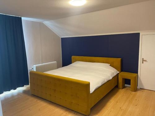 a bed in a room with a blue wall at Apartment Målargården in Uddeholm