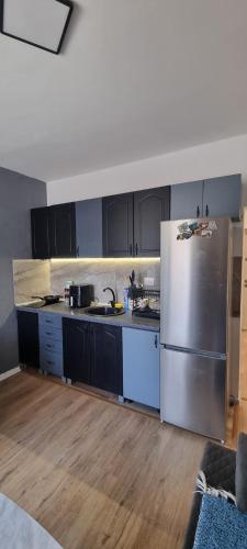 a kitchen with a stainless steel refrigerator and black cabinets at Tri Kule Apartman in Bar