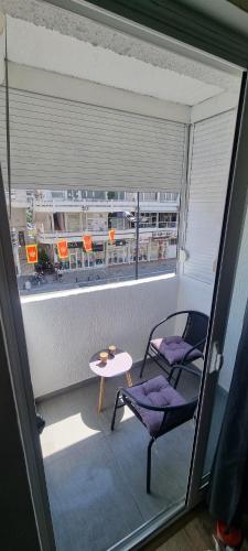 a balcony with a table and a chair and a window at Tri Kule Apartman in Bar