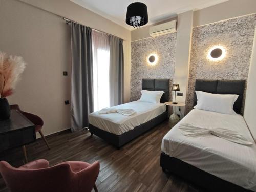 a hotel room with two beds and a chair at Apartment Julia in Paralia Katerinis