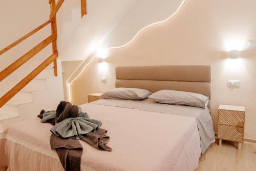 a bedroom with a bed with white sheets and stairs at Domo De Uccio in Alghero