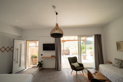 a bedroom with a bed and a chair and a couch at Thyme Suite in Paránimfoi