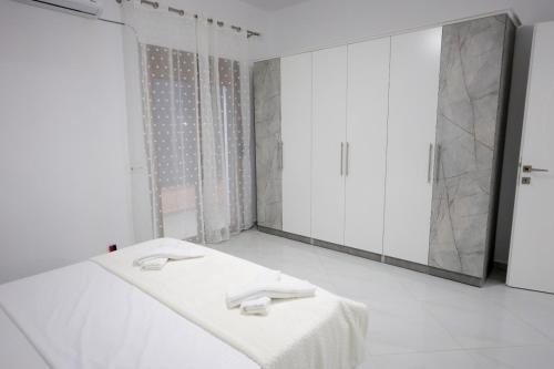 a white room with a mirror and a bed at Vila Lian Apartaments in Belsh