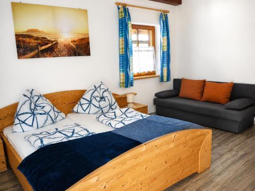 a bedroom with a wooden bed and a couch at Ferienwohnung Dürnberger in Liebenfels