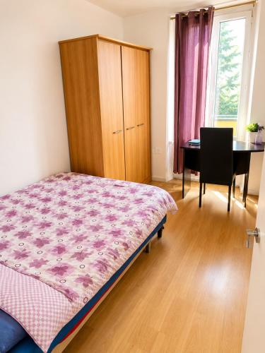 a bedroom with a bed and a desk and a table at Private Room Pré-Saint-Gervais in Le Pré-Saint-Gervais