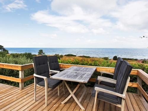 a table and two chairs on a deck with the ocean at 4 star holiday home in Asnæs in Asnæs