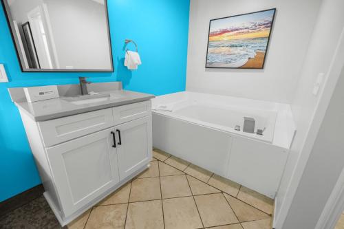 a bathroom with a white tub and a sink and a bath tubermott at Grand Palms Resort in Myrtle Beach
