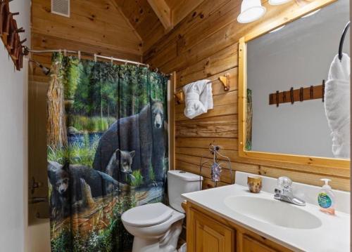 a bathroom with a toilet and a shower curtain at Bearadise Hot Tub 6 Min to The Island in Pigeon Forge