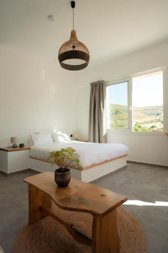 a bedroom with a bed and a table and a potted plant at Lavender Suite in Paránimfoi