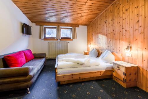 a bedroom with a bed and a couch in it at Hotel Lamm in San Valentino alla Muta