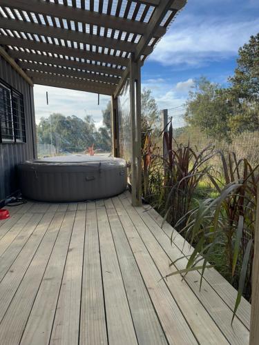a hot tub on a deck with a pergola at MiRe- Alojamiento con jacuzzi in Maldonado