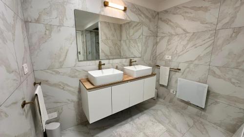 a white bathroom with two sinks and a mirror at Panorama Terrace - Como Lake in Como