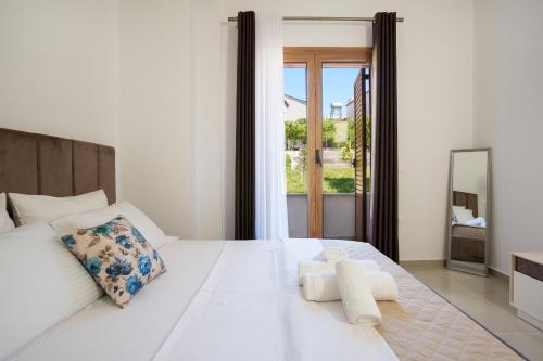a bedroom with a large white bed with towels on it at Oasis White in Durrës