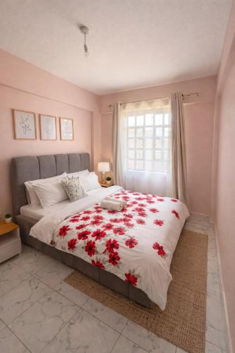 a bedroom with a large bed with red flowers on it at The Legend Place in Eldoret