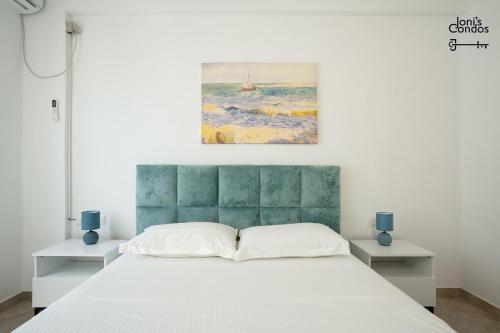 a bedroom with a bed and a painting on the wall at Joni's Twin Condos (Pool&Pine View) in Golem