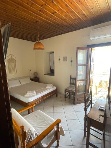 a bedroom with two beds and a table and a window at Little Graceland in Afissos