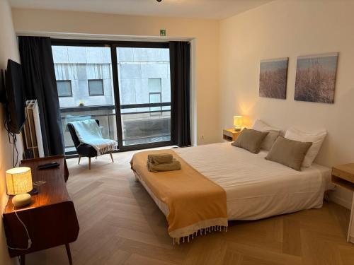 a bedroom with a large bed and a large window at Bérylune Centrum in Ostend