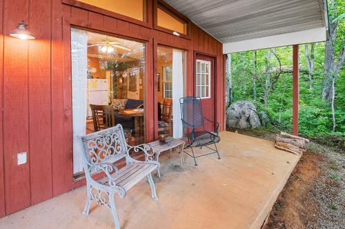 a porch of a red house with a bench at Nolichuckey Bluffs Bed & Breakfast Cabins in Greeneville