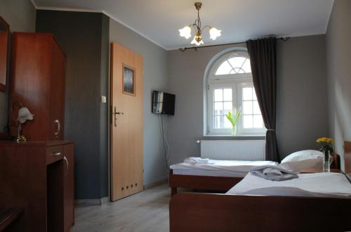 a hotel room with two beds and a window at Dworek Mitro in Gdynia