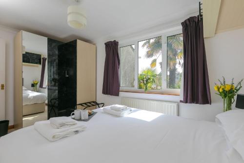a bedroom with a white bed and a window at Ocean Parc in Carbis Bay