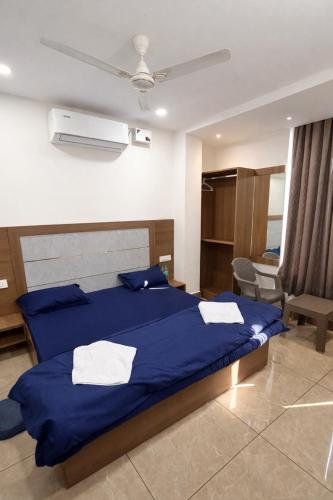 a bedroom with a blue bed with towels on it at Hotel VK in Beās