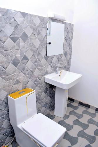 a bathroom with a toilet and a sink at Residence LaFina in Saly Portudal
