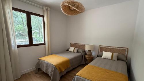 two beds in a room with a window at Finca El Carrascal Arroyo frío, Sierra de Cazorla in Arroyo Frio