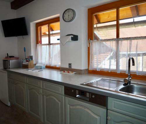 a kitchen with a sink and a clock on the wall at Ferienwohnung Dürnberger in Liebenfels