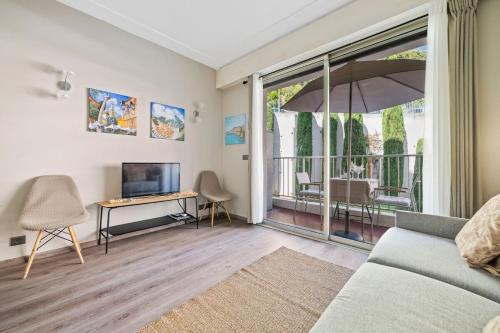 a living room with a couch and a tv at La Plage - Studio - Face à la Mer - Clim Terrasse in Menton