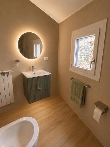 a bathroom with a tub and a sink and a window at La casina di Viola in Posticciola