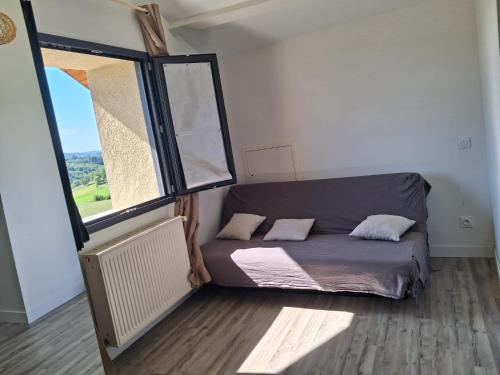 a bed in a room with a large window at Les violettes du Bugey in Marchamp