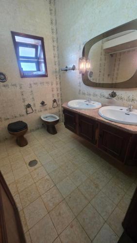 a bathroom with two sinks and a toilet and a mirror at Aveiro, Veneza Portuguesa in Oliveirinha