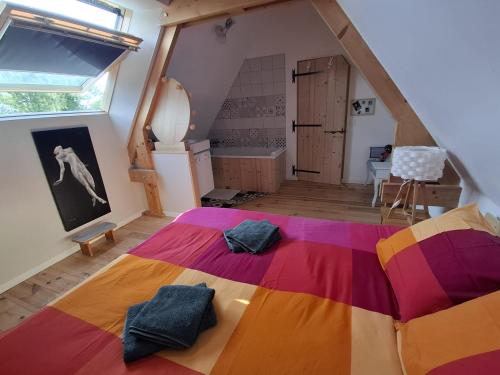 a bedroom with a colorful bed in a attic at Chez les Wawas in Sainte-Agathe-dʼAliermont