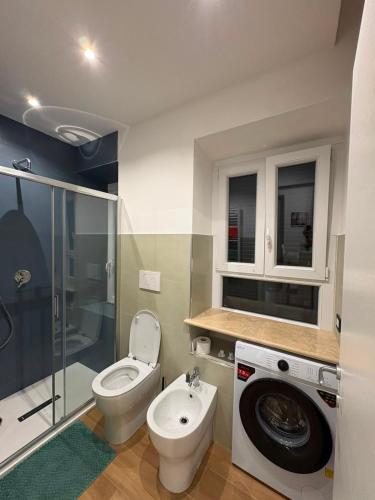a bathroom with a toilet and a sink and a washing machine at ADA City Apartment in Palestrina