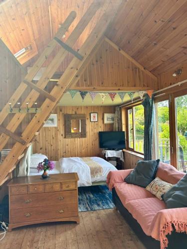 a bedroom with a bed and a couch in a room at Portlea Cabin in Oban