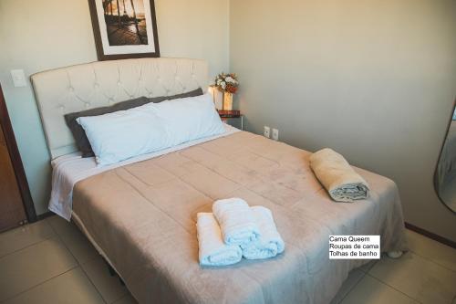 a bedroom with a bed with towels on it at VIVA - Centro - Garagem - Apt 1 Dormitório in Santa Maria