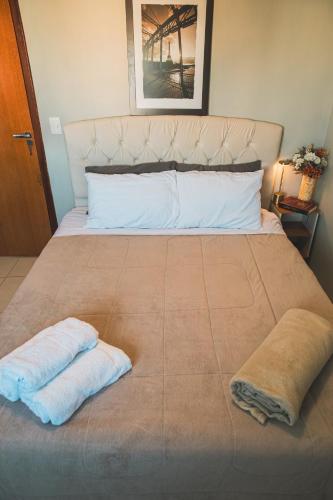 a bed with two towels sitting on top of it at VIVA - Centro - Garagem - Apt 1 Dormitório in Santa Maria