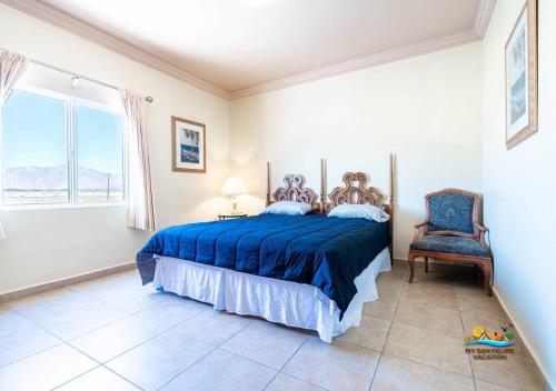 a bedroom with a bed and a chair and a window at Jerry in San Felipe
